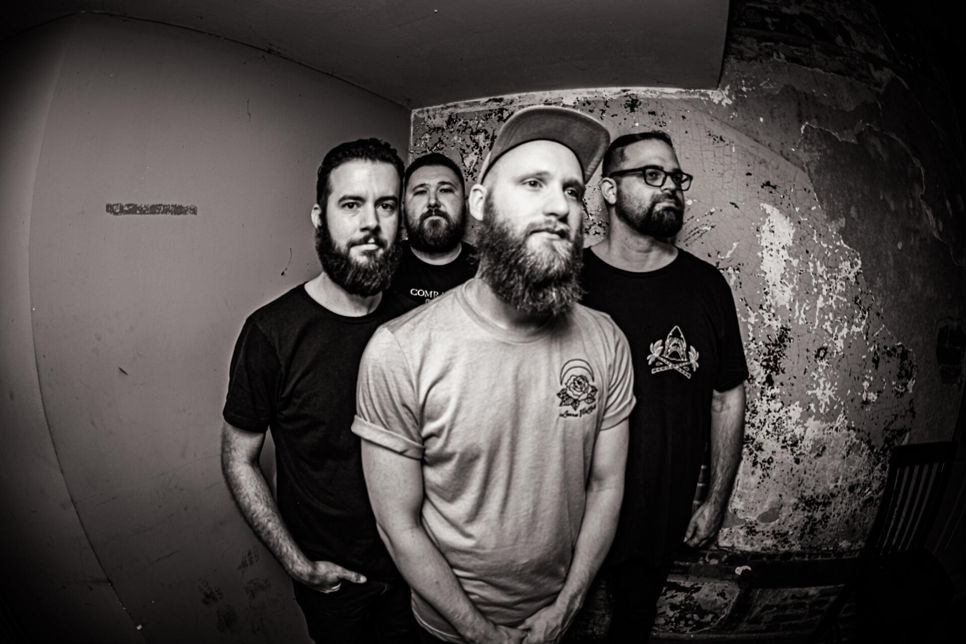 Members of the band Dens in the corner of a venue